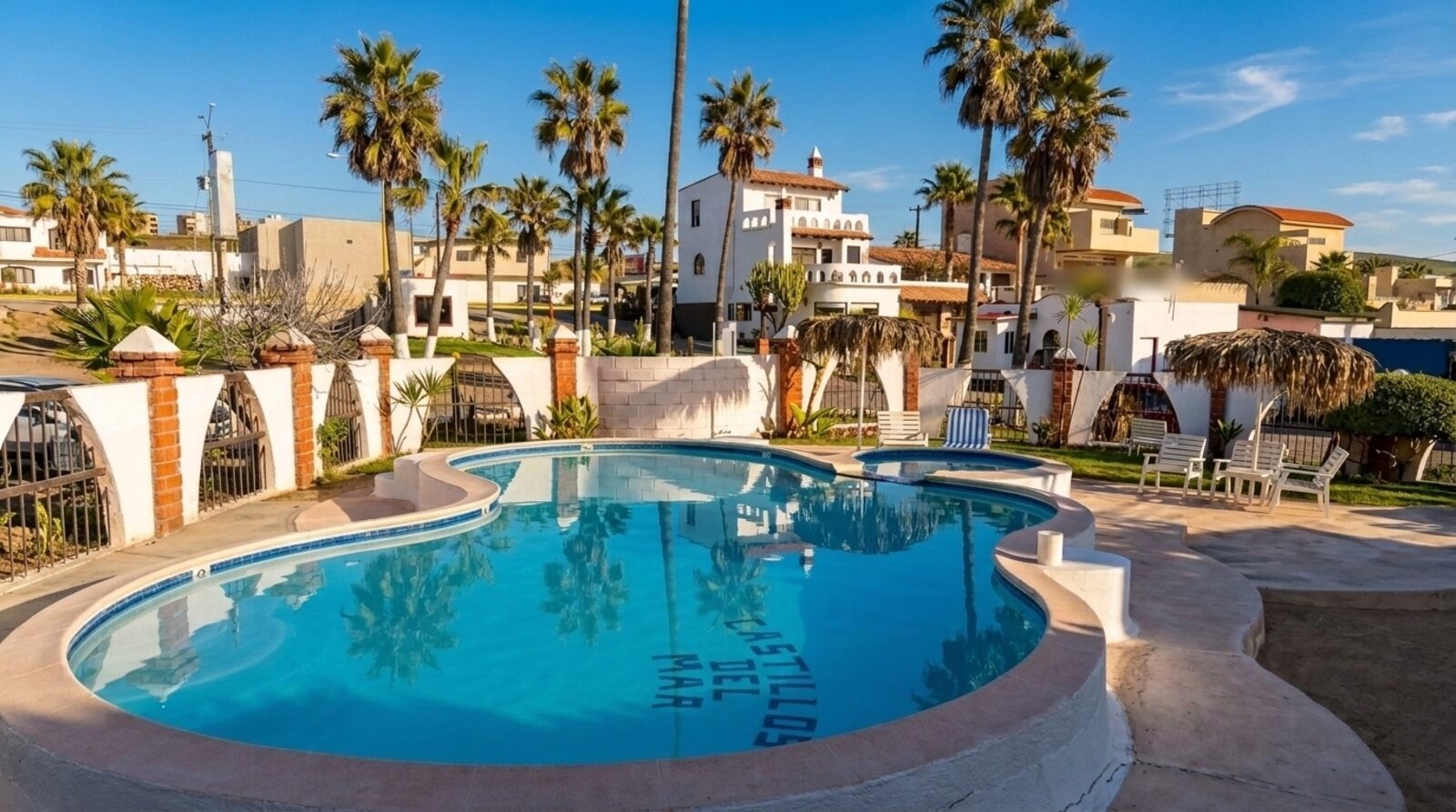 La alberca del hotel, con su nombre azulejado en el fondo, entre arcos de ladrillo y palmeras.